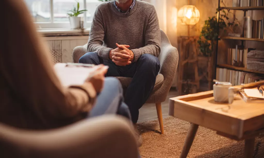 Person sitting in a warm, comfortable therapy room during an individual counseling session at an outpatient rehab center in Massachusetts