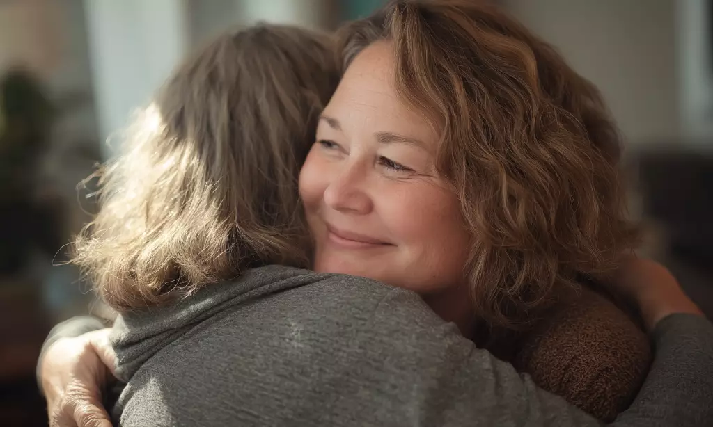Woman smiling as she hugs a loved one, symbolizing family support and emotional healing during addiction recovery in Chelmsford, Massachusetts