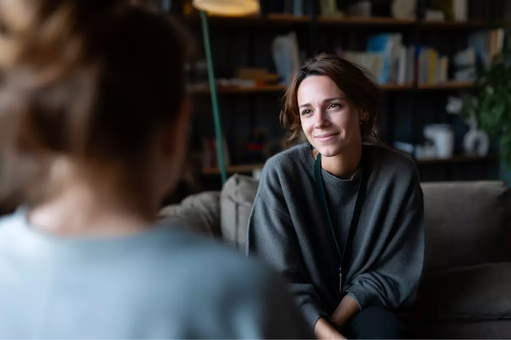 Compassionate therapist listening attentively to a client during a counseling session in a calm, comfortable Massachusetts treatment center.