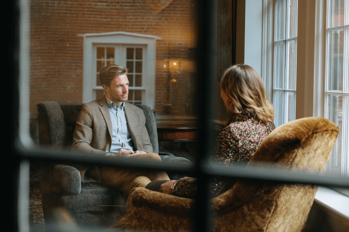 Therapist and client talking in a calm Massachusetts office using motivational interviewing techniques.